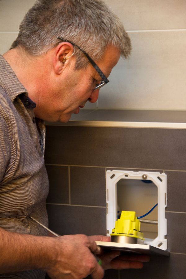 Peter Zegers monteert een inbouwreservoir voor een toilet